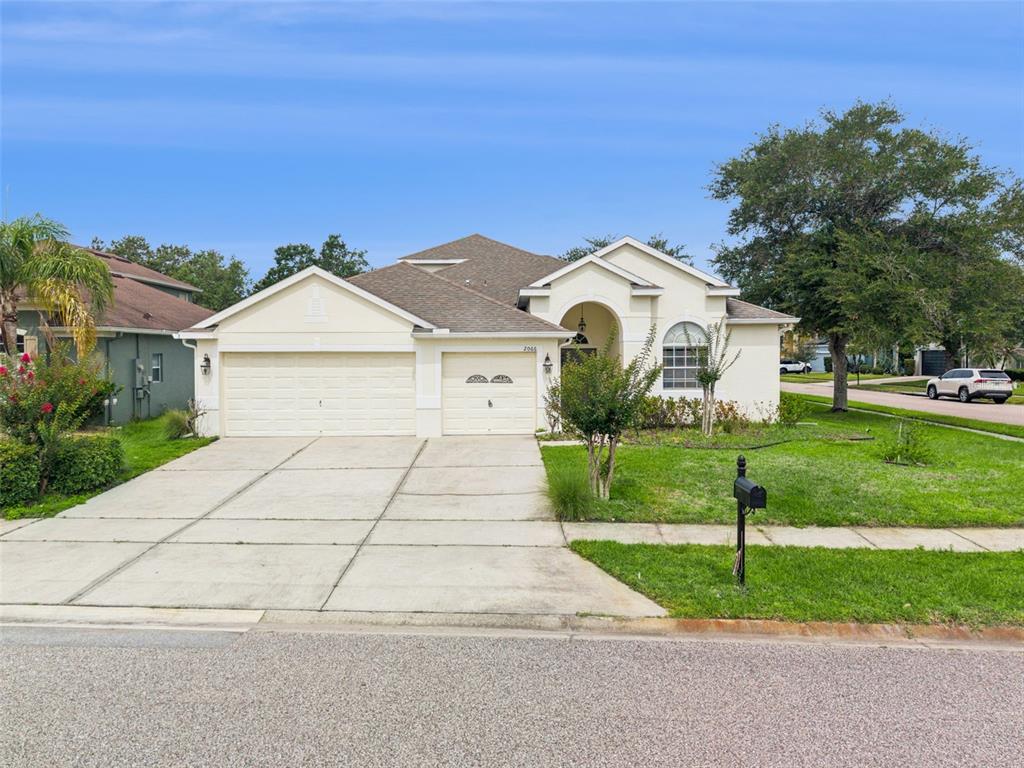 A single-story house with a beige exterior, a three-car garage, and a front lawn — 2066 GLORIA OAK COURT, ORLANDO, FL