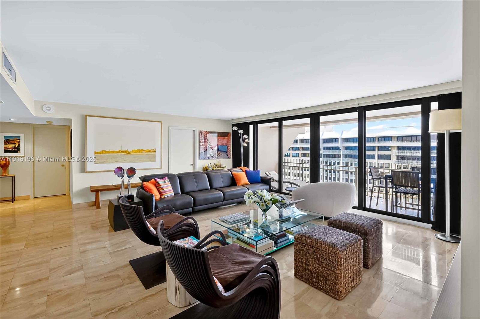 A living room features a dark leather sofa, glass coffee table, and floor-to-ceiling windows — 2 Grove Isle Dr # B1804, Coconut Grove FL 33133, COCONUT GROVE, FL
