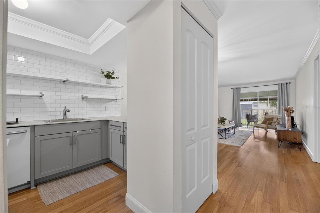 A kitchen with gray cabinets and white subway tile walls opens into a living area — 3812 N OAK DRIVE UNIT M32, TAMPA, FL