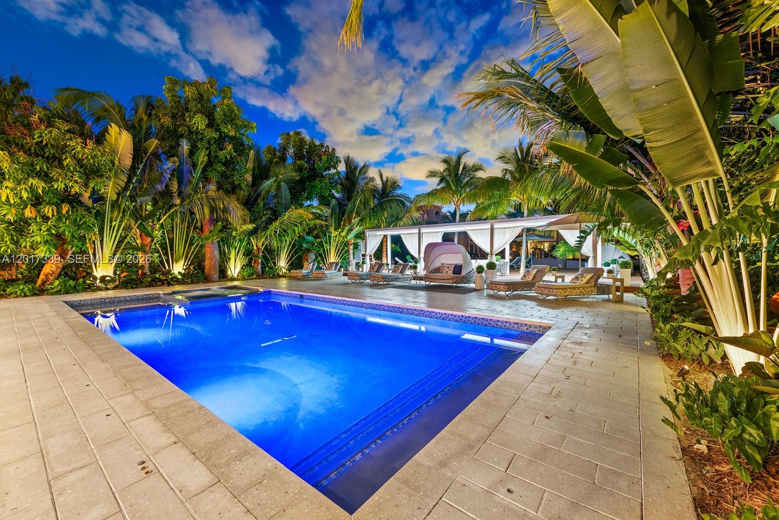A rectangular swimming pool sits on a stone patio surrounded by lush tropical landscaping — 3734 Chase Ave, Miami Beach FL 33140, MIAMI BEACH, FL