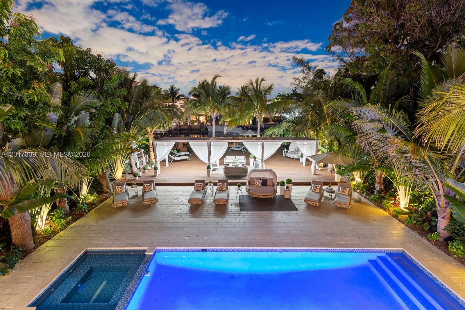 A backyard features a swimming pool, a stone patio, and a covered wooden deck area — 3734 Chase Ave, Miami Beach FL 33140, MIAMI BEACH, FL