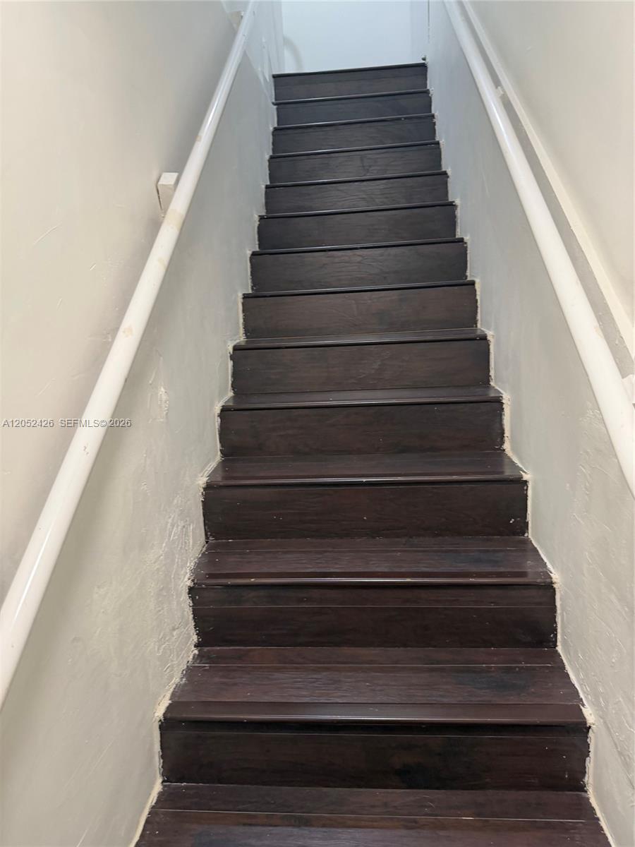 A straight staircase features dark wood treads and white handrails on both sides — 13889 SW 140th St # 547, Miami FL 33186, MIAMI, FL