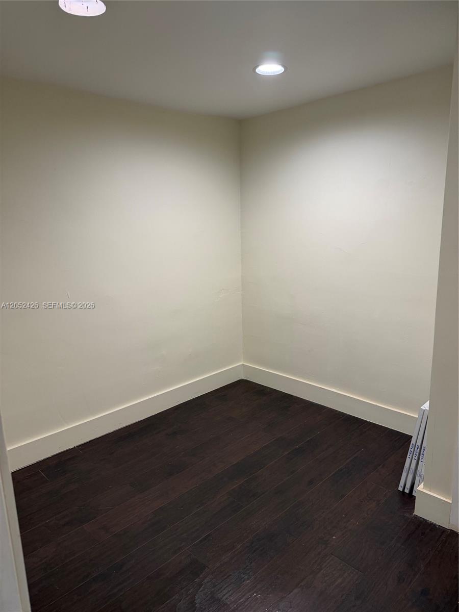 This small, empty room features dark wood-look flooring, off-white walls, and recessed ceiling lighting — 13889 SW 140th St # 547, Miami FL 33186, MIAMI, FL