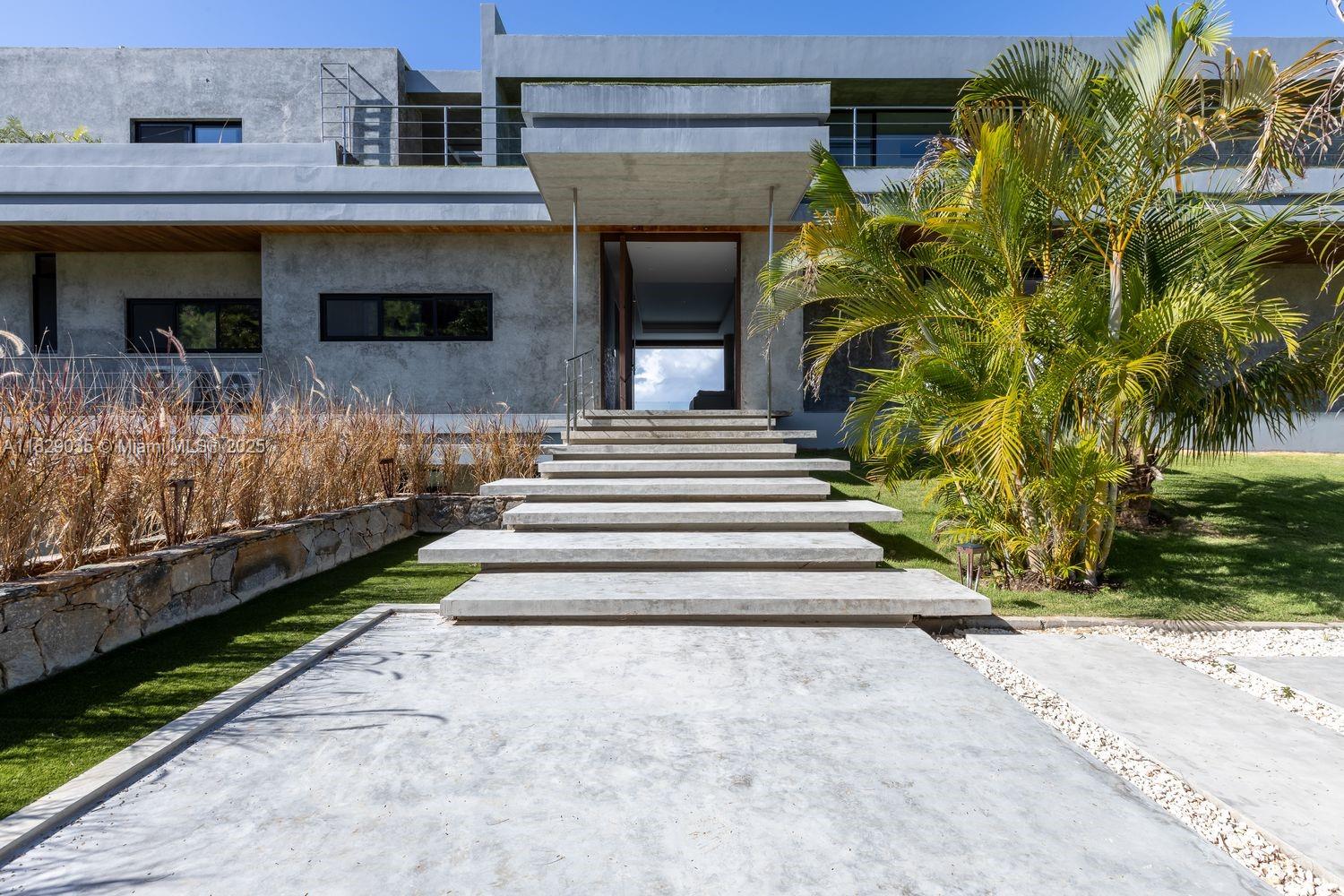 A modern concrete house features a wide staircase leading to an open entryway — 000 8G99+hr Las Terrenas, Dominican Republic, FL 32000, FL