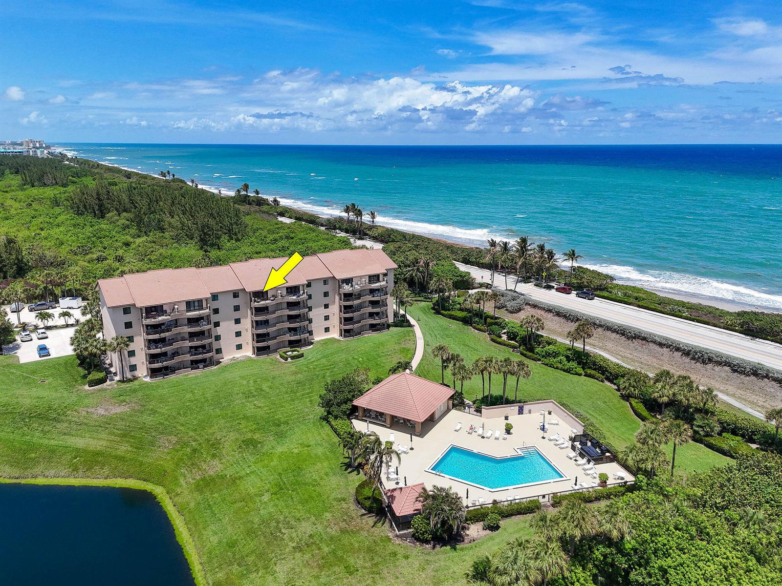 An aerial view shows a multi-story residential building with a pool and oceanfront location — 101 Ocean Bluffs Boulevard # 504, Jupiter FL 33477, JUPITER, FL