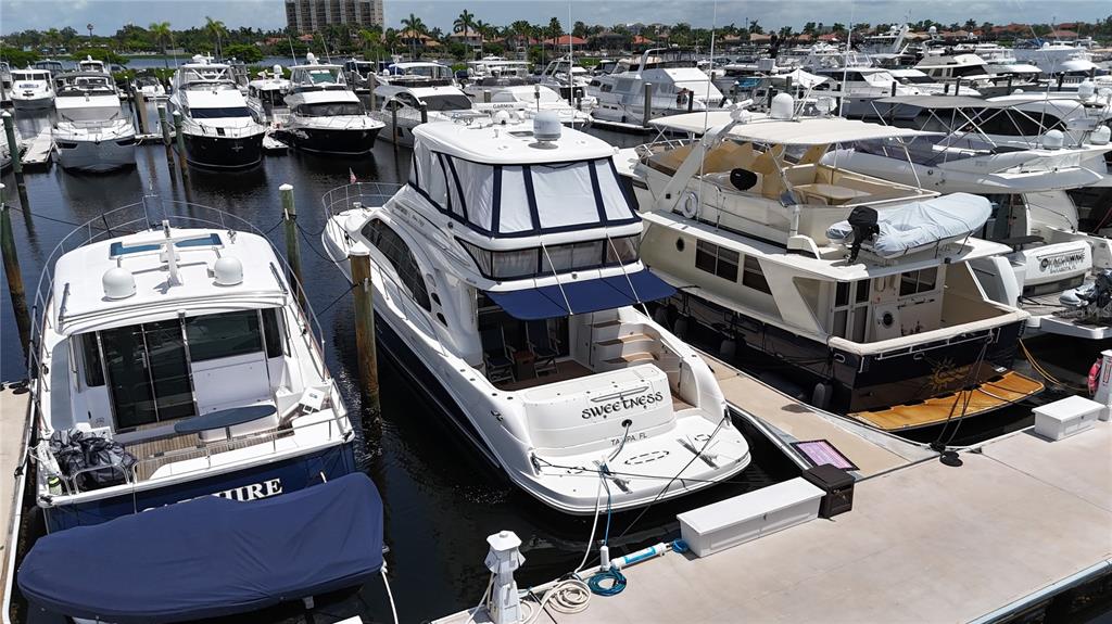 An elevated view shows several yachts docked in a marina with calm water — 102 RIVIERA DUNES WAY UNIT S-11, PALMETTO, FL