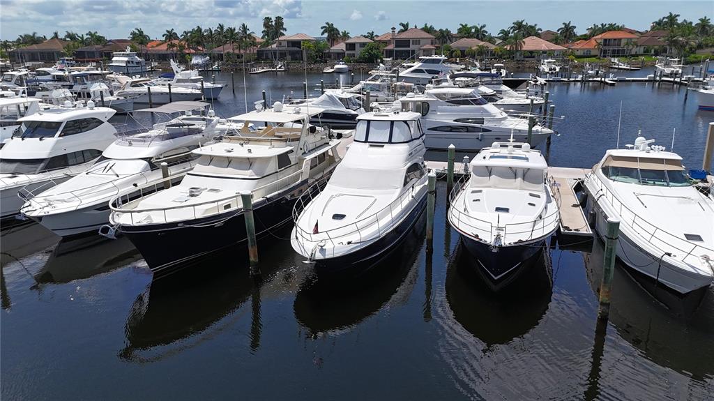 An aerial view shows several white motor yachts docked in a calm marina — 102 RIVIERA DUNES WAY UNIT S-11, PALMETTO, FL