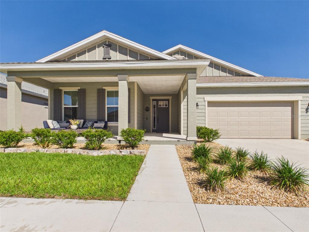A single-story house with a front porch, a two-car garage, and a landscaped front yard — 7813 SW 56TH PLACE, OCALA, FL