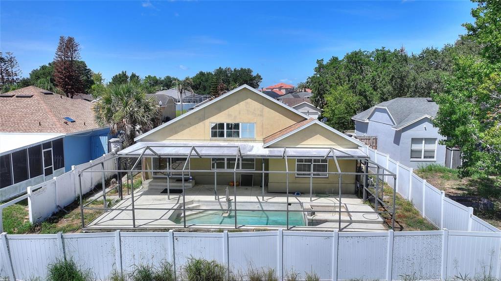 A yellow house with a screened-in pool and patio area enclosed by a white fence — 844 BERWICK DR, DAVENPORT, FL
