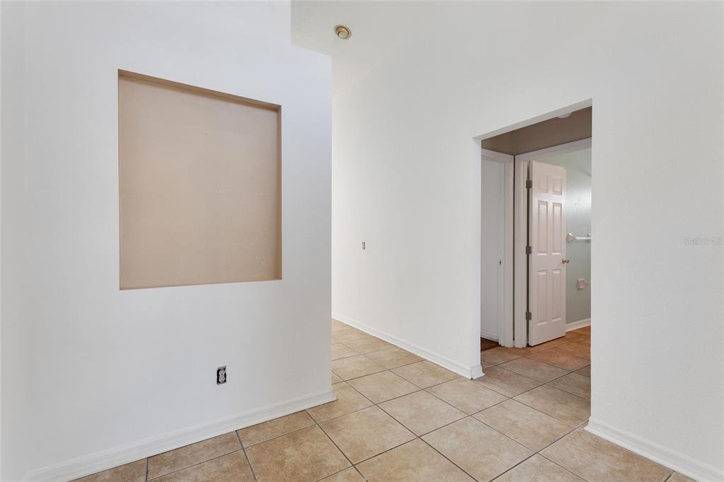 A hallway with tiled floors leads to a doorway with a white door — 844 BERWICK DR, DAVENPORT, FL