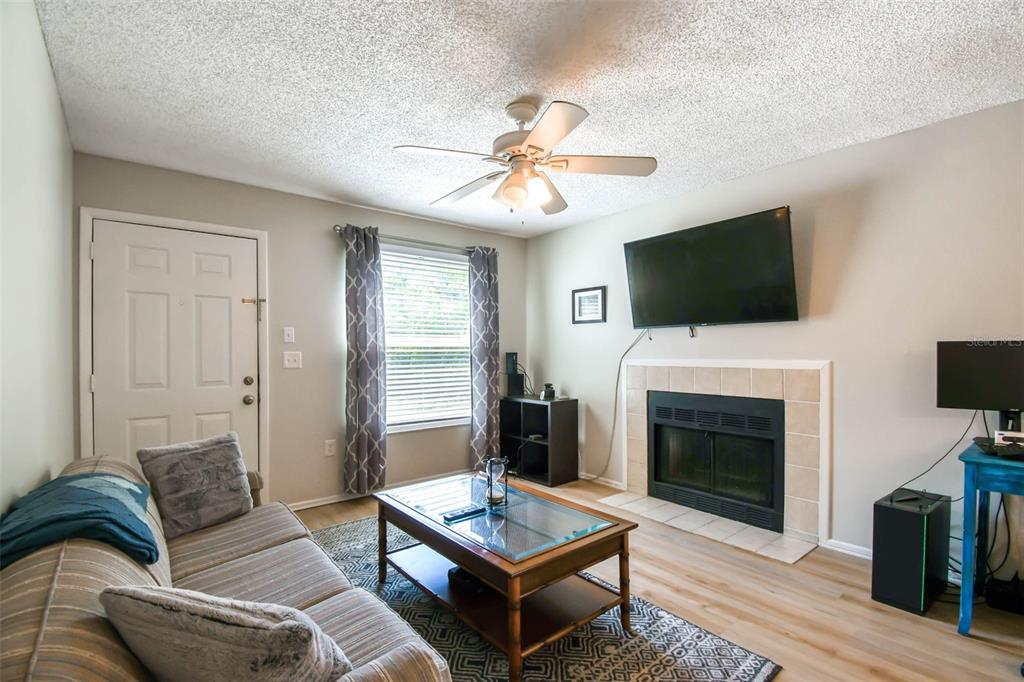 A living room features a fireplace, a ceiling fan, a sofa, and a coffee table — 3718 59TH AVE W UNIT 3718, BRADENTON, FL