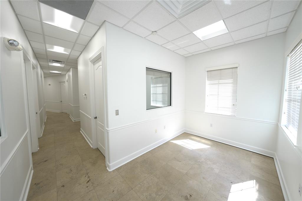 An empty office space with white walls, tile flooring, a window, and a hallway entrance — 2009 LONGWOOD LAKE MARY ROAD, LONGWOOD, FL