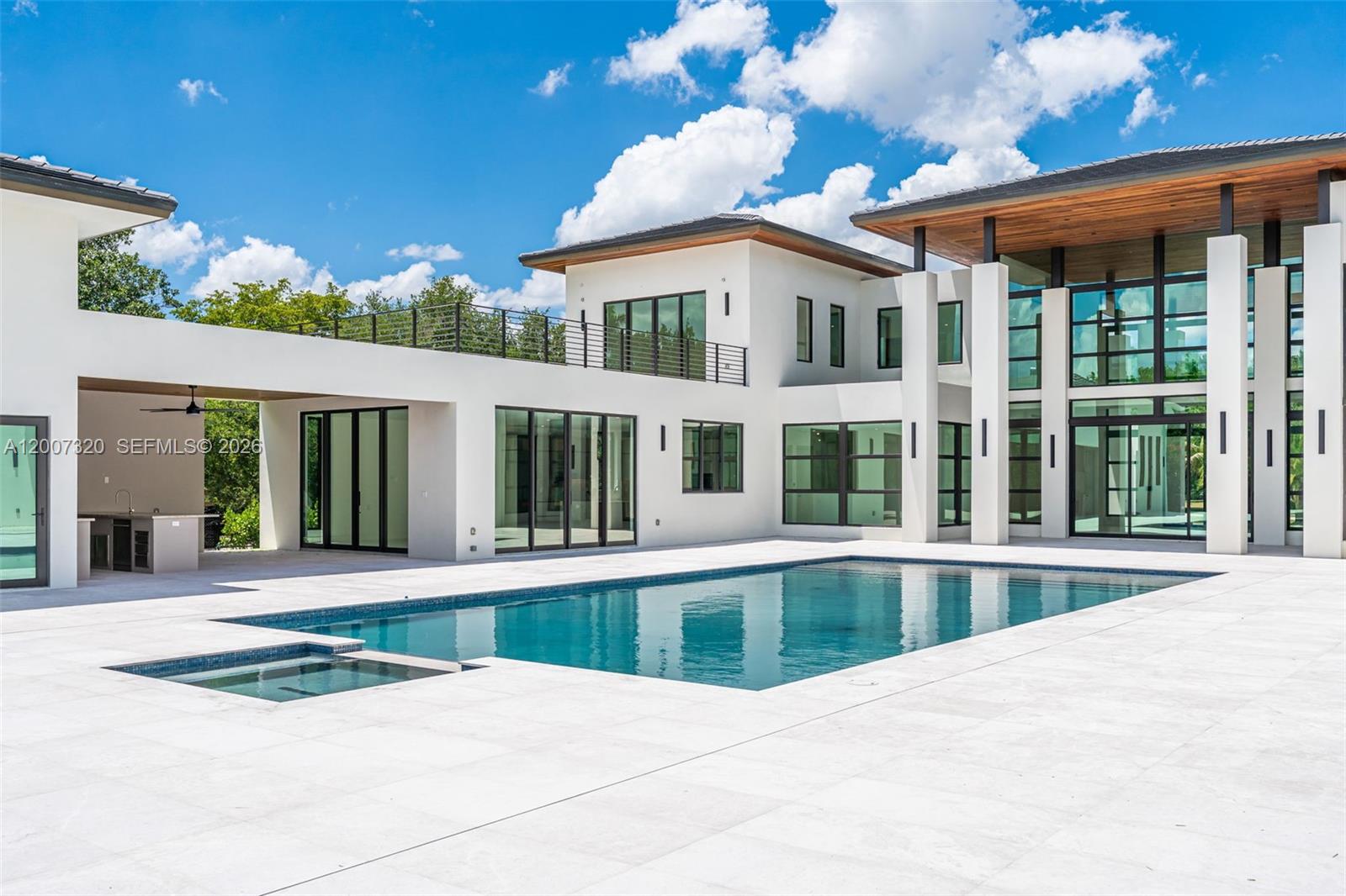 A modern white two-story house features a large swimming pool and a covered outdoor kitchen — 6290 Chapman Field Dr, Pinecrest FL 33156, PINECREST, FL