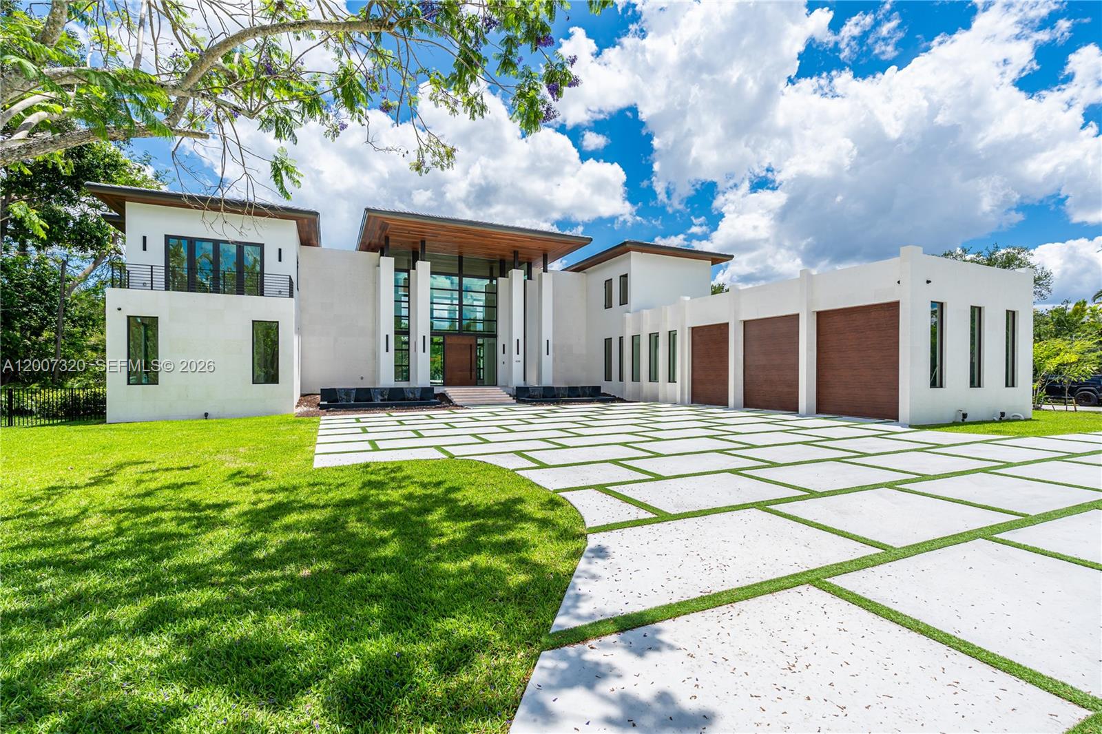 A modern two-story house features a large concrete paver driveway and a three-car garage — 6290 Chapman Field Dr, Pinecrest FL 33156, PINECREST, FL