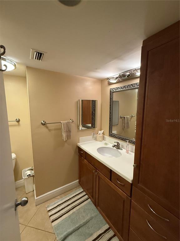 A living room features tile flooring, a ceiling fan, a sofa, and a leather recliner — 1515 PINELLAS BAYWAY S UNIT 42, ST PETERSBURG, FL