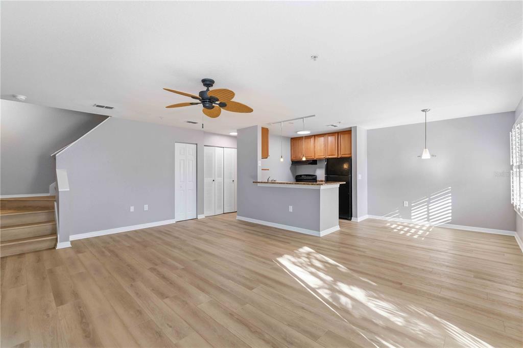 An open-concept living and dining area features light wood-look flooring, gray walls, and a kitchen — 850 S TAMIAMI TRAIL UNIT 630, SARASOTA, FL