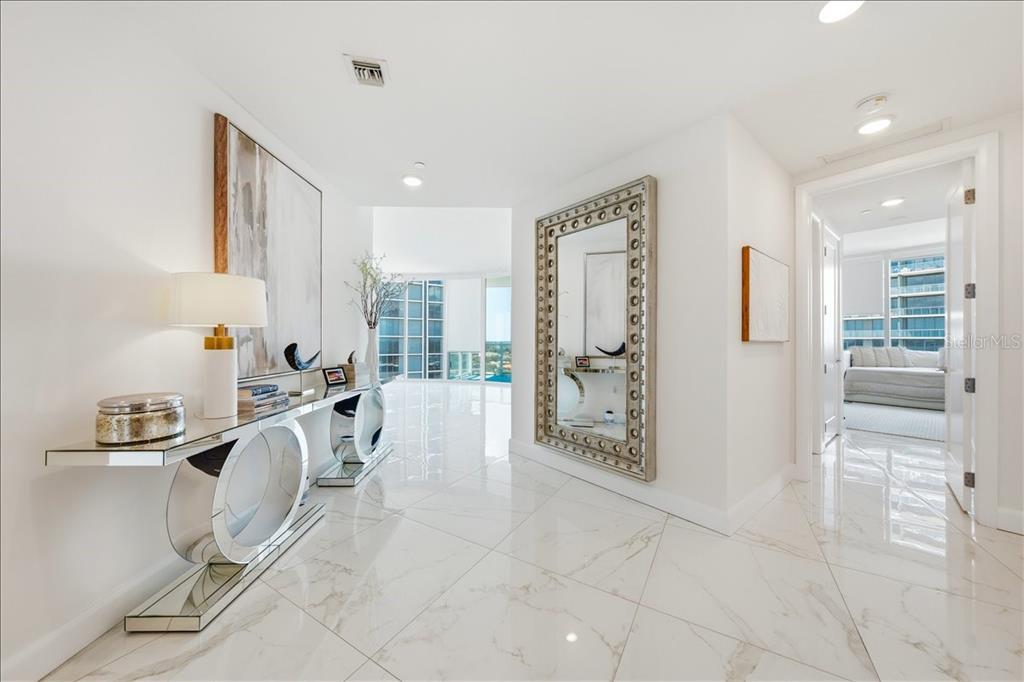 A bright, modern entryway features white marble floors, a mirrored console table, and a large mirror — 2900 W BAY TO BAY BOULEVARD UNIT 1401, TAMPA, FL