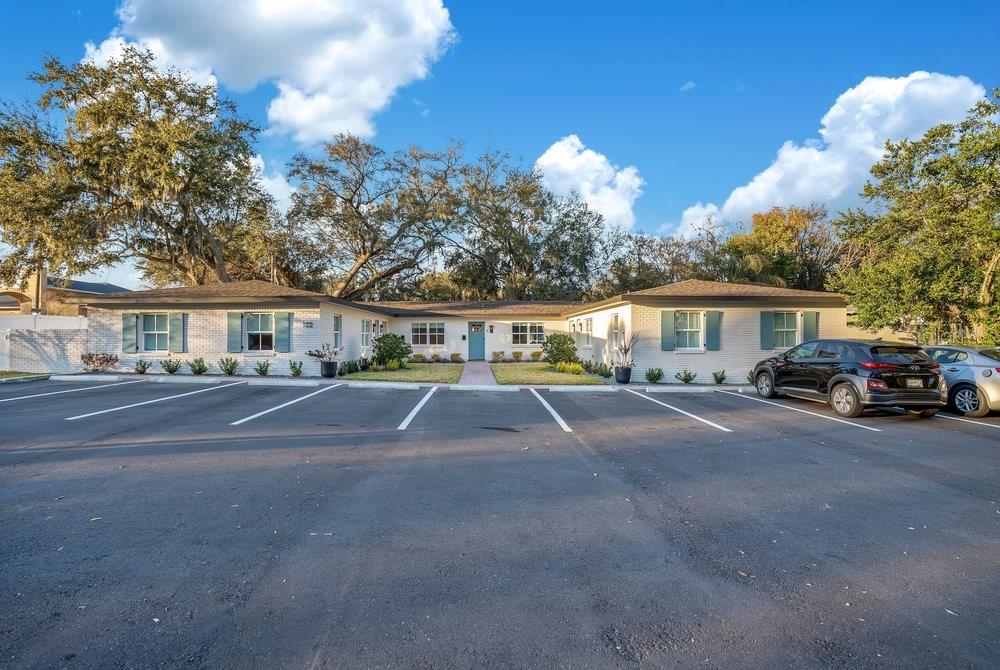 A single-story brick building with a parking lot in front and mature trees behind — 122 E BELMAR STREET UNIT D, LAKELAND, FL