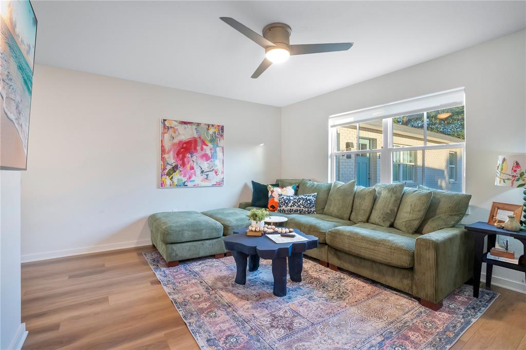 A living room features a green sectional sofa, a dark coffee table, and a rug — 122 E BELMAR STREET UNIT D, LAKELAND, FL