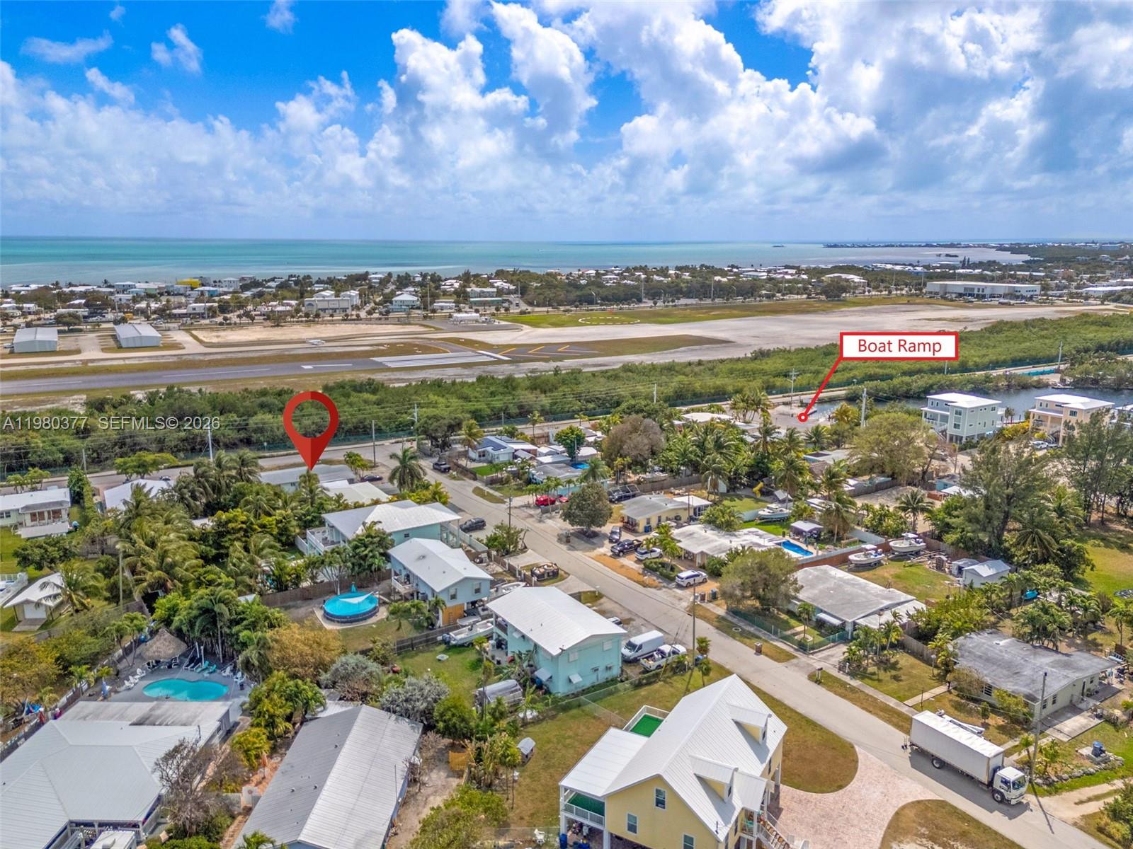 This aerial view shows a residential neighborhood near an airport runway and a boat ramp — 1262 Marlin Dr, Marathon FL 33050, MARATHON, FL