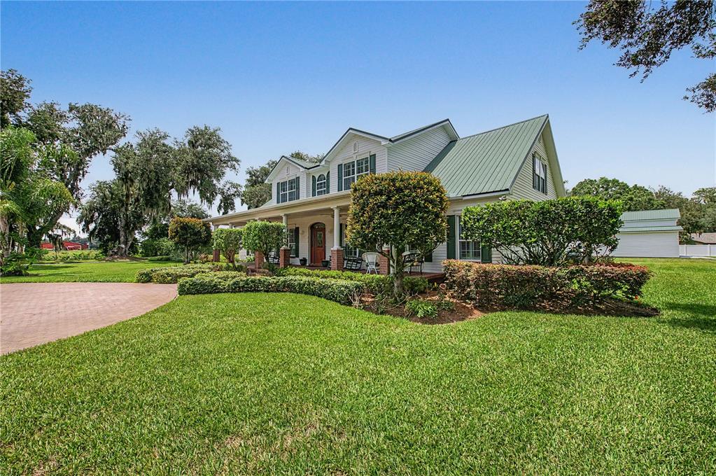 A two-story house with a green metal roof and a covered front porch — 3660 FUTCH LOOP, PLANT CITY, FL