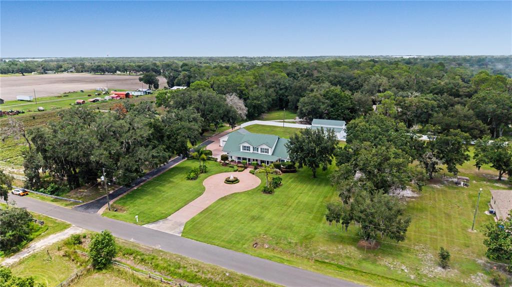An aerial view shows a large house with a green roof and a circular driveway — 3660 FUTCH LOOP, PLANT CITY, FL