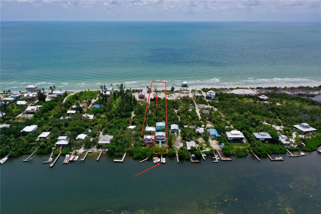 An aerial view shows a narrow waterfront property lot extending from a bay to the beach — 8164, 8168, 8158, 8156 LITTLE GASPARILLA ISLAND, PLACIDA, FL