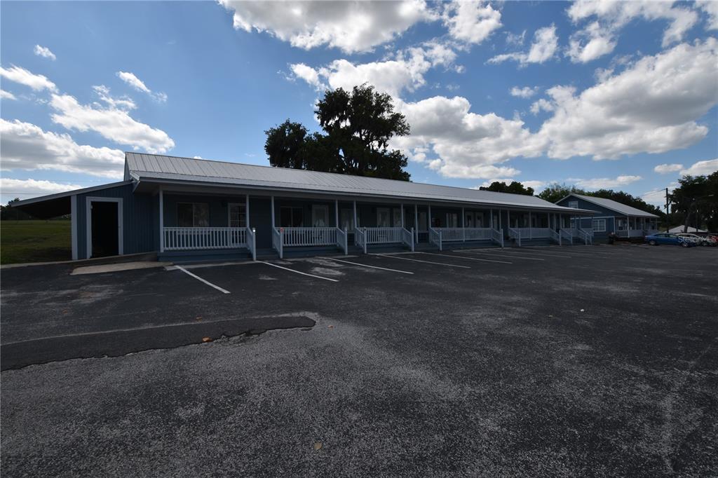A long, single-story blue building with a metal roof and a covered front porch — 704 S LAKESHORE BOULEVARD, HOWEY IN THE HILLS, FL