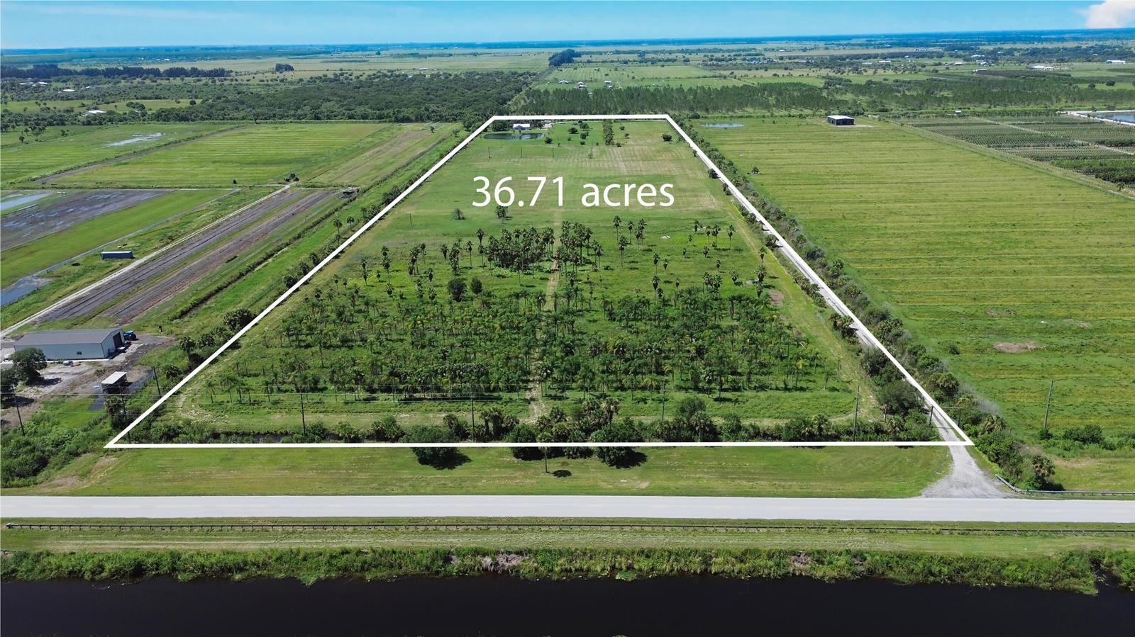 An aerial view shows a 36.71-acre rectangular plot of land bordered by a road — 18601 Orange Avenue, Fort Pierce FL 34945, FORT PIERCE, FL