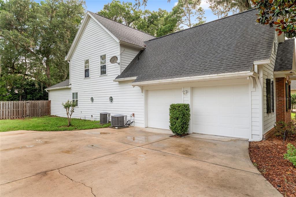 A two-story house exterior features white siding, a two-car garage, and two air conditioning units — 5512 NW 51ST AVENUE, GAINESVILLE, FL