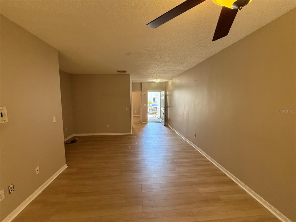 An interior view of a living area with light wood-look flooring and a front door — 6030 OSPREY LAKE CIRCLE, RIVERVIEW, FL