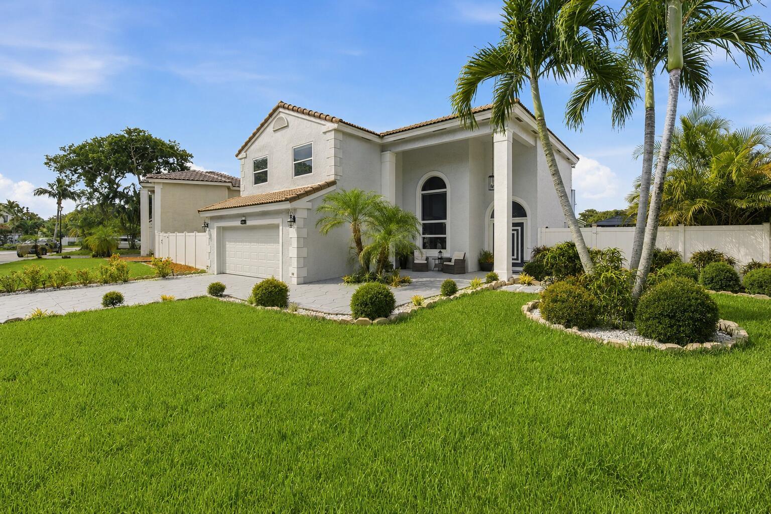 A two-story house with a garage, a paved driveway, and palm trees in the front yard — 14040 Richwood Place, Davie FL 33325, DAVIE, FL