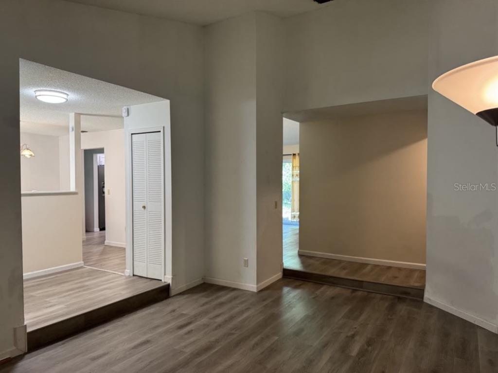 An interior view shows a room with wood-look flooring, white walls, and two arched openings — 5523 WESTVIEW DRIVE, ORLANDO, FL