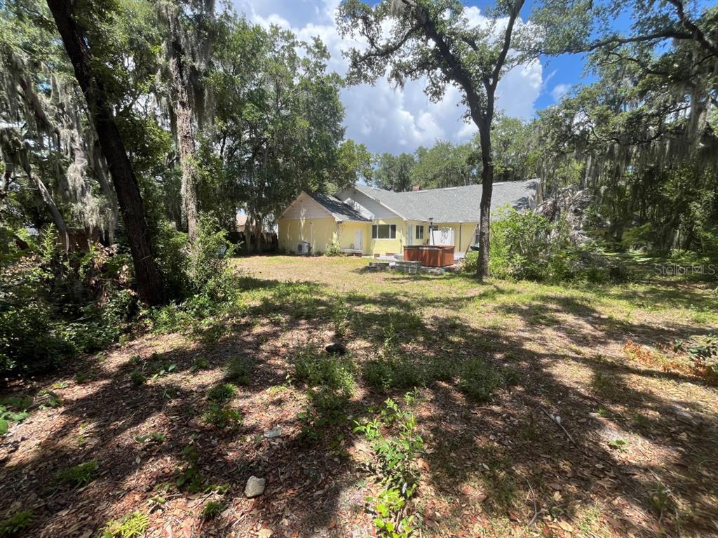 A yellow house with a garage and a driveway surrounded by large oak trees — 310 CLAYTON ROAD, AUBURNDALE, FL