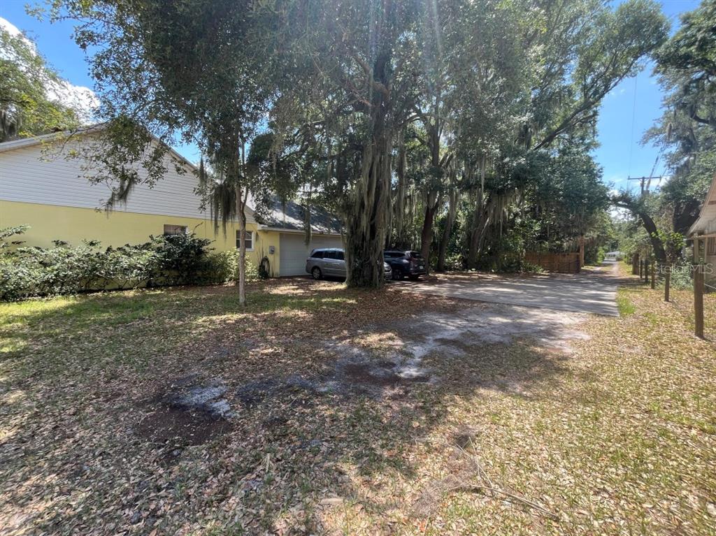 A wooded lot with large oak trees draped in Spanish moss leads toward a distant house — 310 CLAYTON ROAD, AUBURNDALE, FL