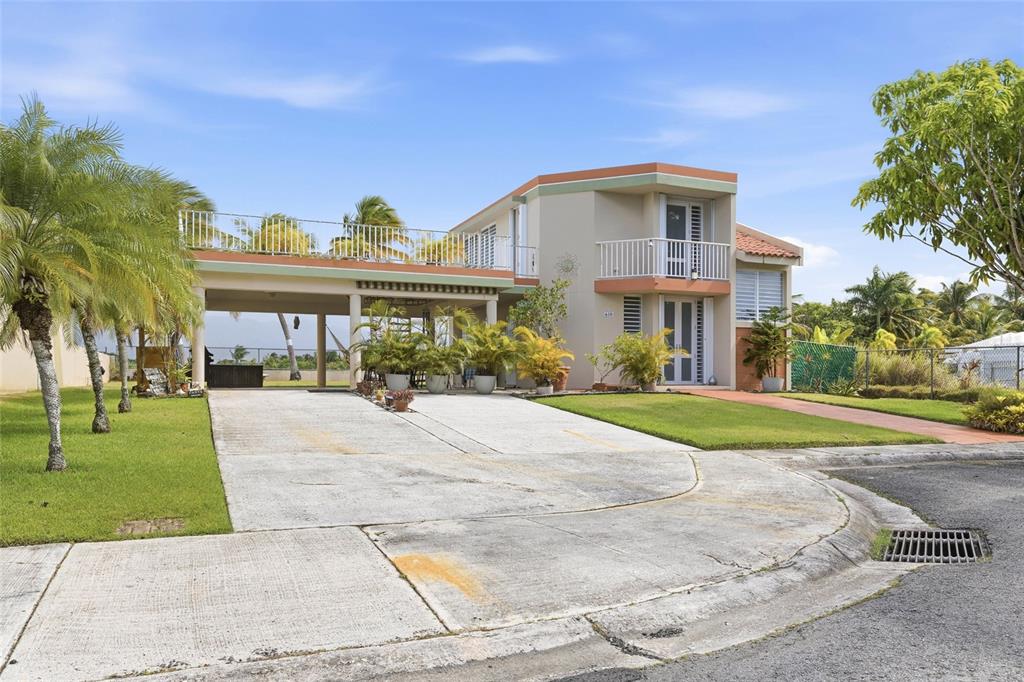 A two-story house with a large carport, a second-floor balcony, and a concrete driveway — 610 CALLE VISTAMAR, RIO GRANDE, PR