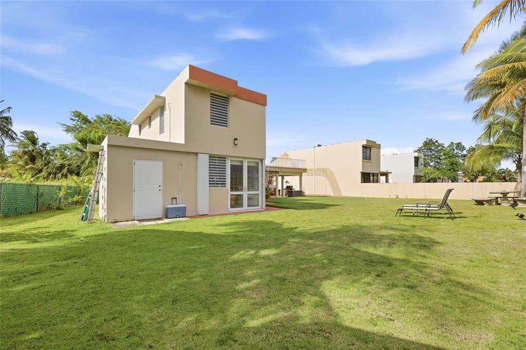 A two-story house with a flat roof and a large grassy backyard — 610 CALLE VISTAMAR, RIO GRANDE, PR
