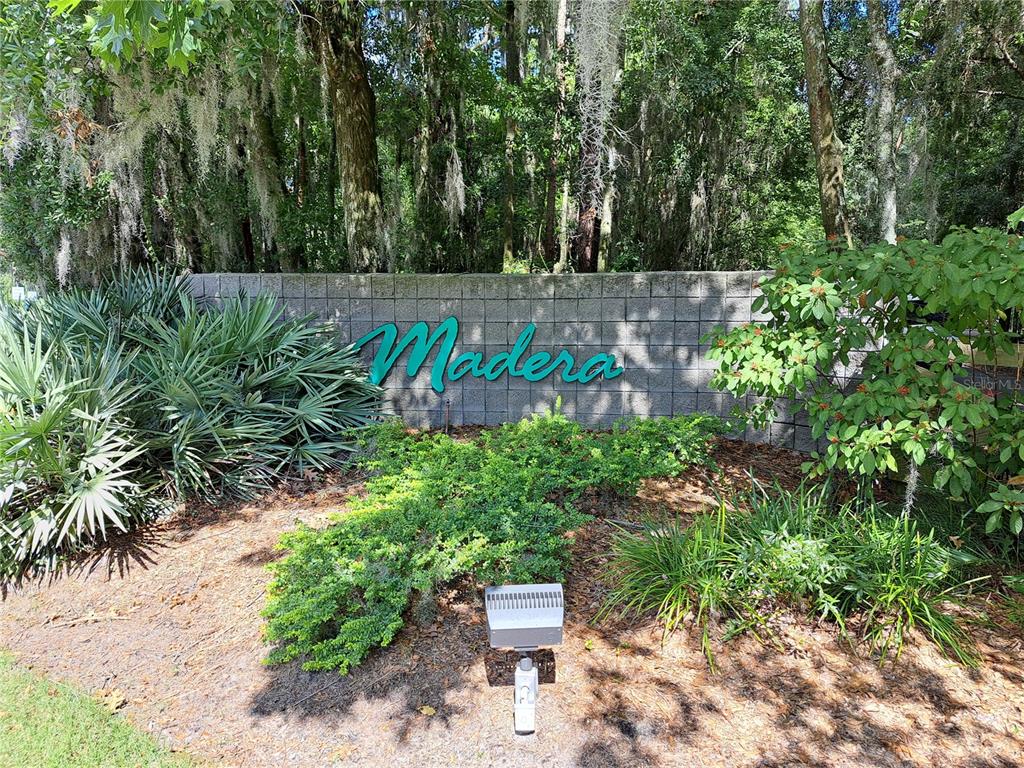 A stone wall with the word Madera sits in front of trees and landscaping — 2164 SW 37TH COURT, GAINESVILLE, FL