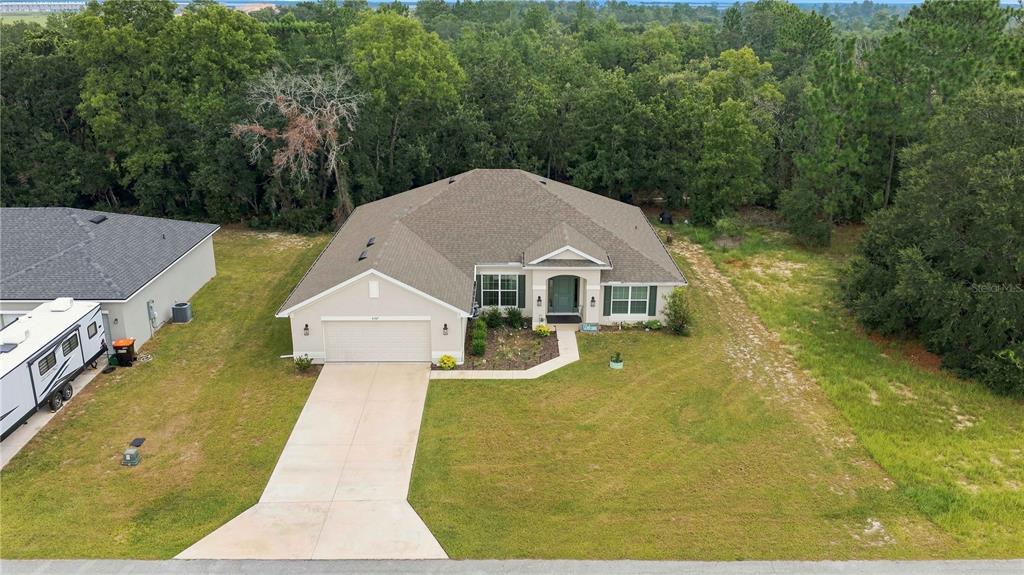 An aerial view shows a single-story house with a garage, driveway, and surrounding wooded yard — 5367 SW 150TH LANE, OCALA, FL