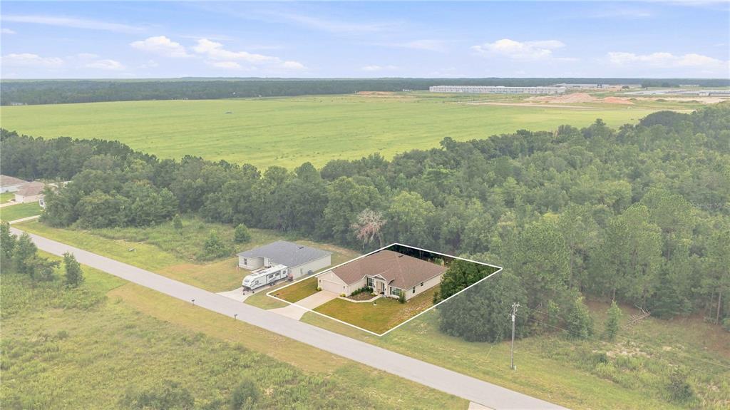 An aerial view shows a single-story house with a driveway and yard beside a forest — 5367 SW 150TH LANE, OCALA, FL