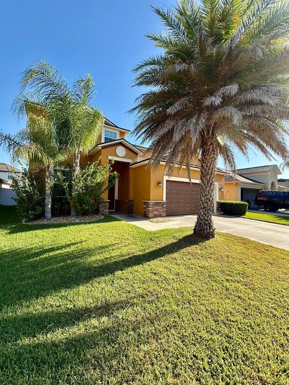 A room with beige carpet and built-in white cabinets sits beside a tiled entryway — 12404 BALLENTRAE FOREST DRIVE, RIVERVIEW, FL