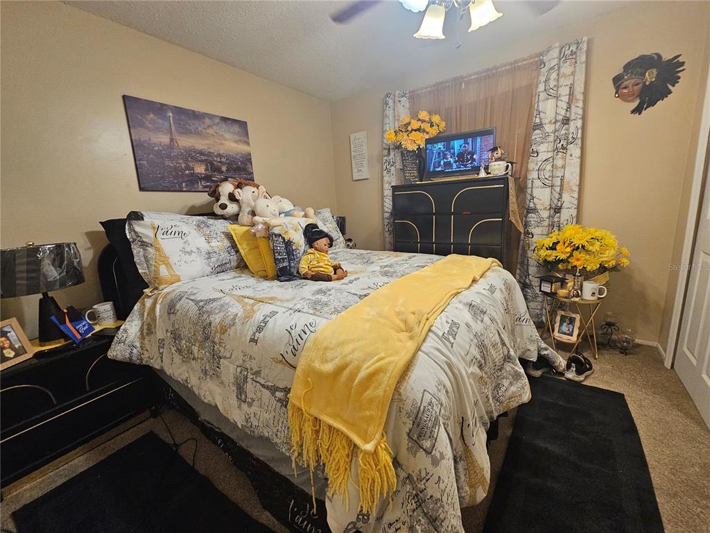 A bedroom features a bed with Paris-themed bedding, a black dresser, and yellow floral accents — 3300 JAMES STREET, MELBOURNE, FL