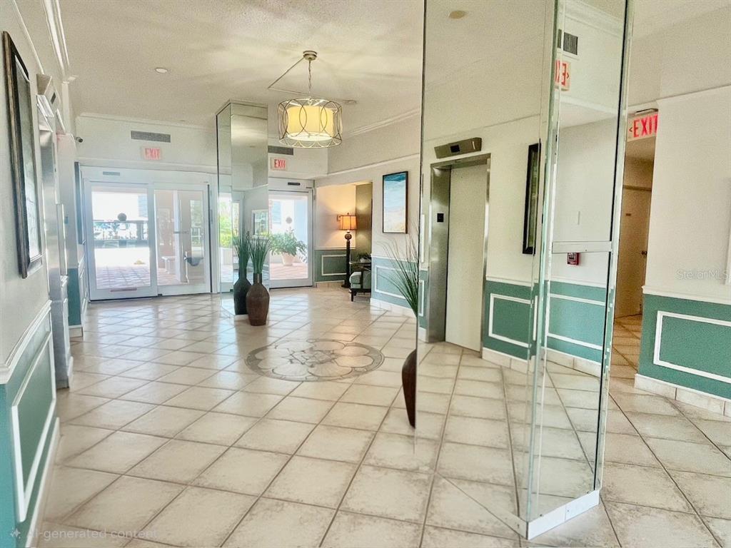 A bright lobby features tiled floors, a mirrored pillar, an elevator, and glass entry doors — 851 BAYWAY BOULEVARD UNIT 405, CLEARWATER BEACH, FL