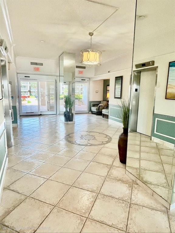 A bright building lobby features tiled floors, a central pendant light, and an elevator entrance — 851 BAYWAY BOULEVARD UNIT 405, CLEARWATER BEACH, FL