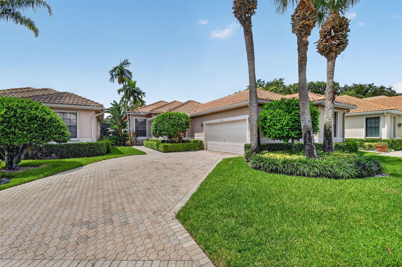 A single-story house with a paved driveway, tile roof, and palm trees in the front yard — 4548 Barclay Fair Way, Lake Worth FL 33449, LAKE WORTH, FL