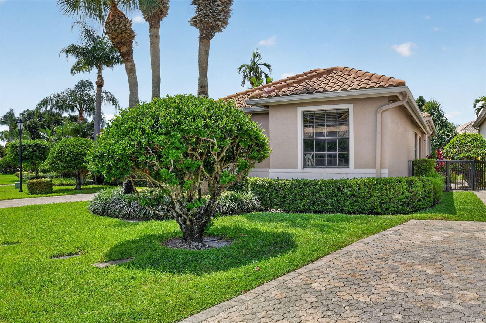 A single-story house with a tiled roof, a paved driveway, and a manicured front lawn — 4548 Barclay Fair Way, Lake Worth FL 33449, LAKE WORTH, FL