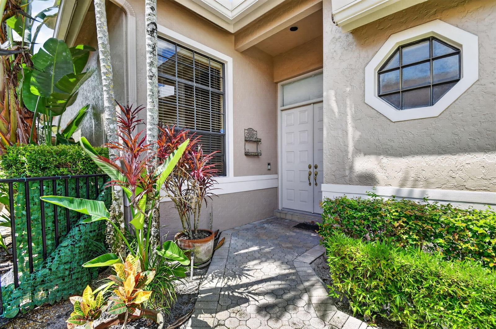 A paved walkway leads to the front entrance of a house with a double door — 4548 Barclay Fair Way, Lake Worth FL 33449, LAKE WORTH, FL
