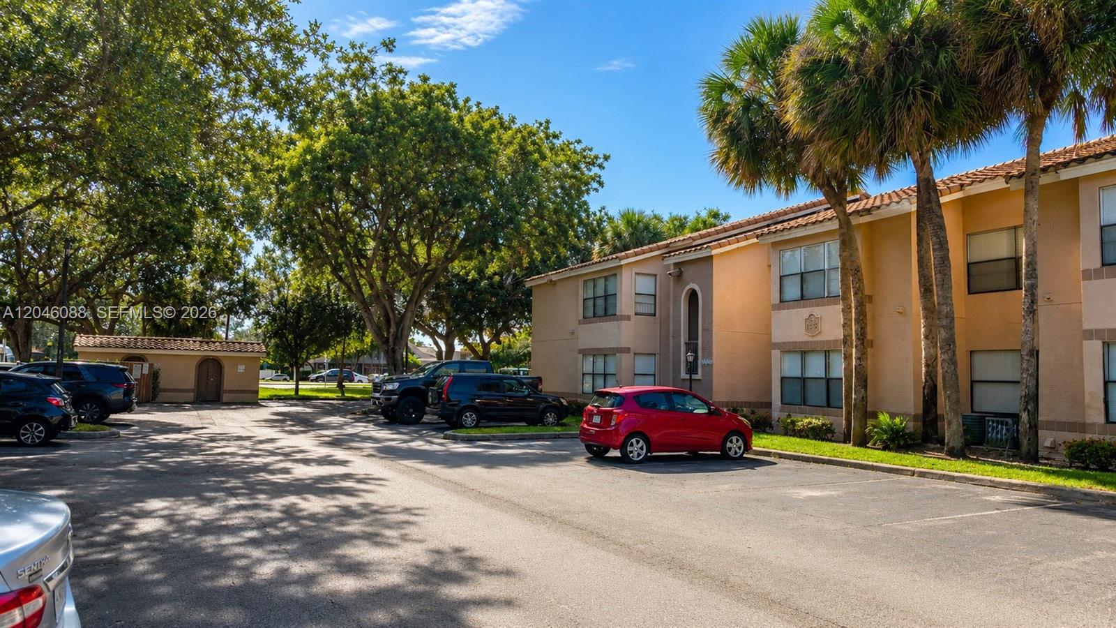 A two-story apartment building with a parking lot and palm trees in front — 2986 S University Dr # 8108, Davie FL 33328, DAVIE, FL