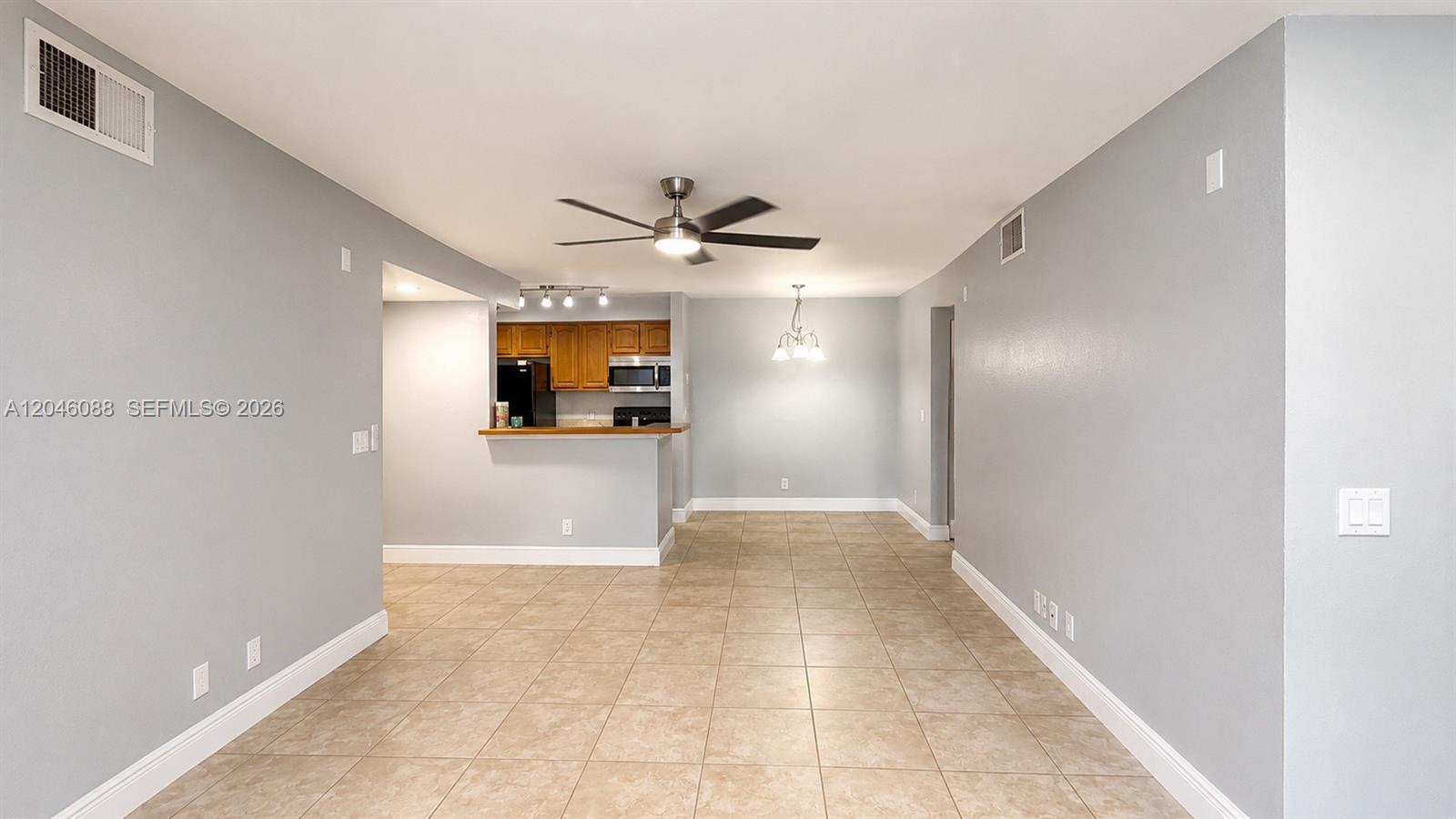 An open-concept dining area features light gray walls, tile flooring, and a kitchen pass-through — 2986 S University Dr # 8108, Davie FL 33328, DAVIE, FL