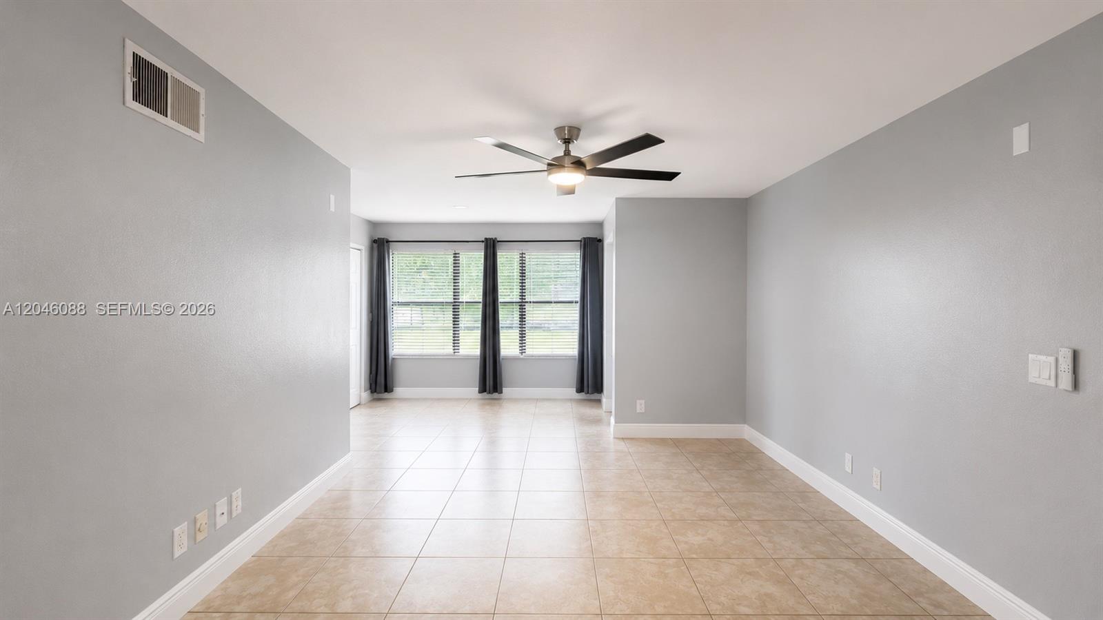 An empty room features light gray walls, beige tile flooring, and a ceiling fan — 2986 S University Dr # 8108, Davie FL 33328, DAVIE, FL